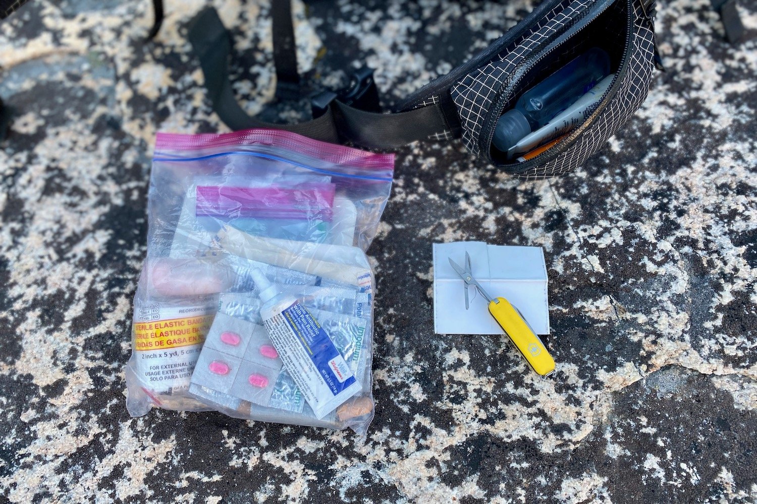 Closeup of a backpacker's custom first aid kit in a Ziploc bag and the Swiss Army Classic multitool
