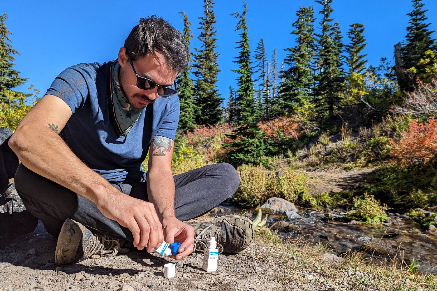 A backpacker using Aquamira drops to purify water on the Timberline Trail.
