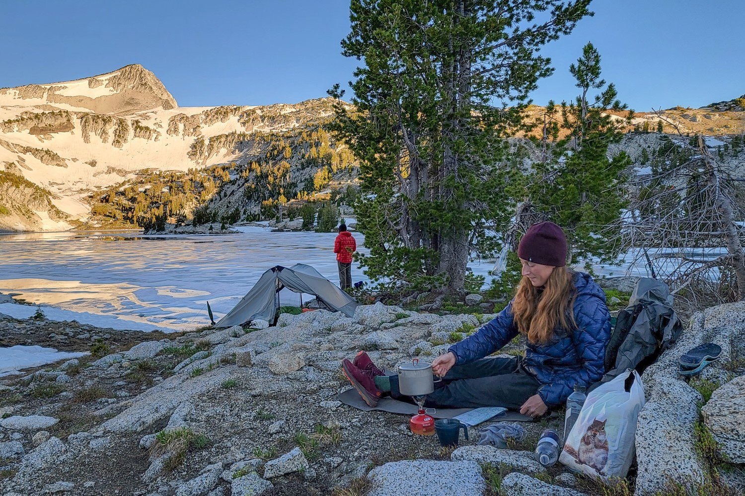 A backpacker cooking a freeze-dried meal near Glacier Lake in the Wallowas.