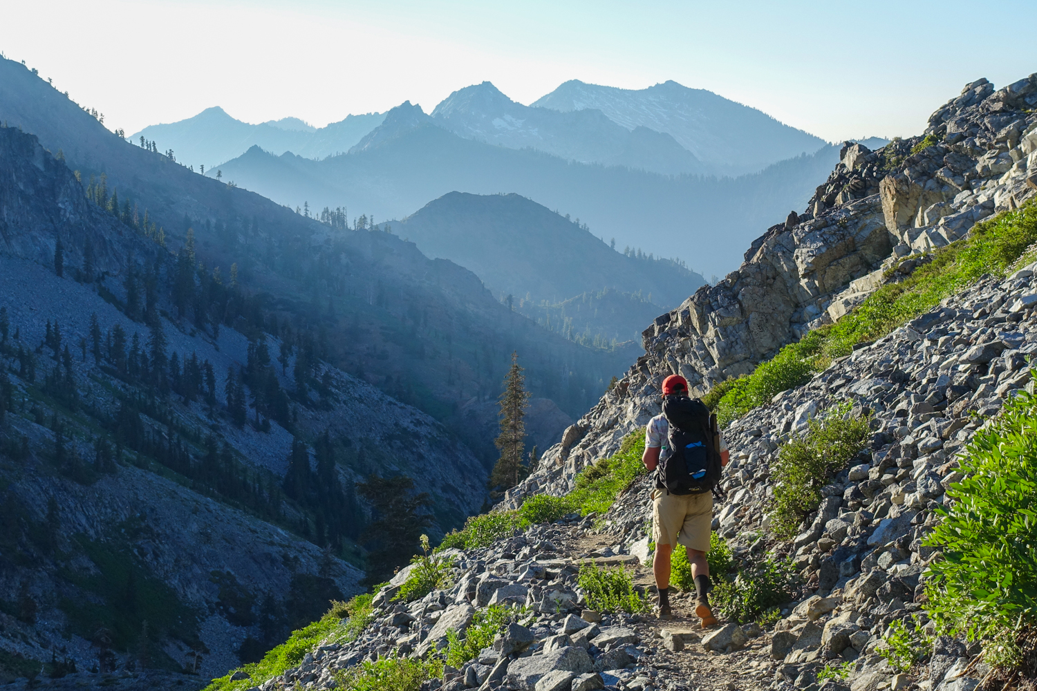 backpacker in the trinity alps with hazy mountains in the background