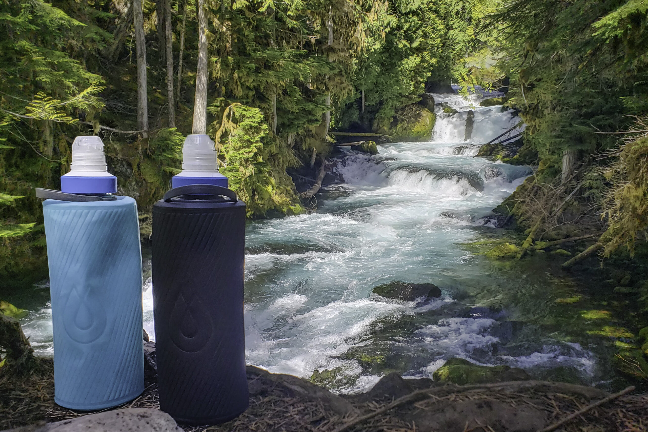 Hydrapak Flux water bottles with Katadyn BeFree water filters in front of a clear-blue river
