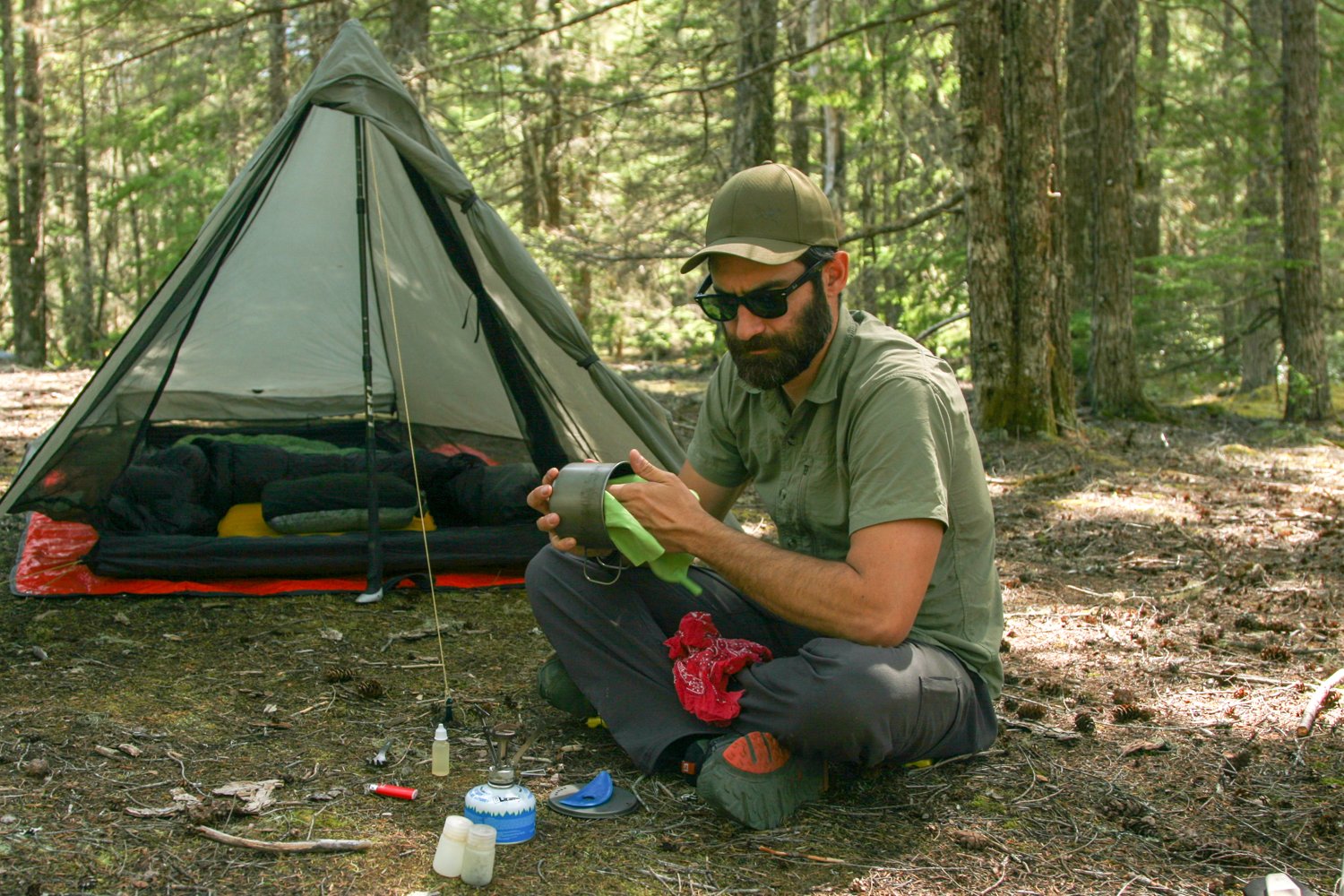 A hiker wiping a pot with a bandana