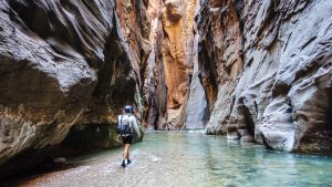 A hiker wearing an Hyperlite Mountain Gear Ultralight Backpack in a slot canyon in Utah