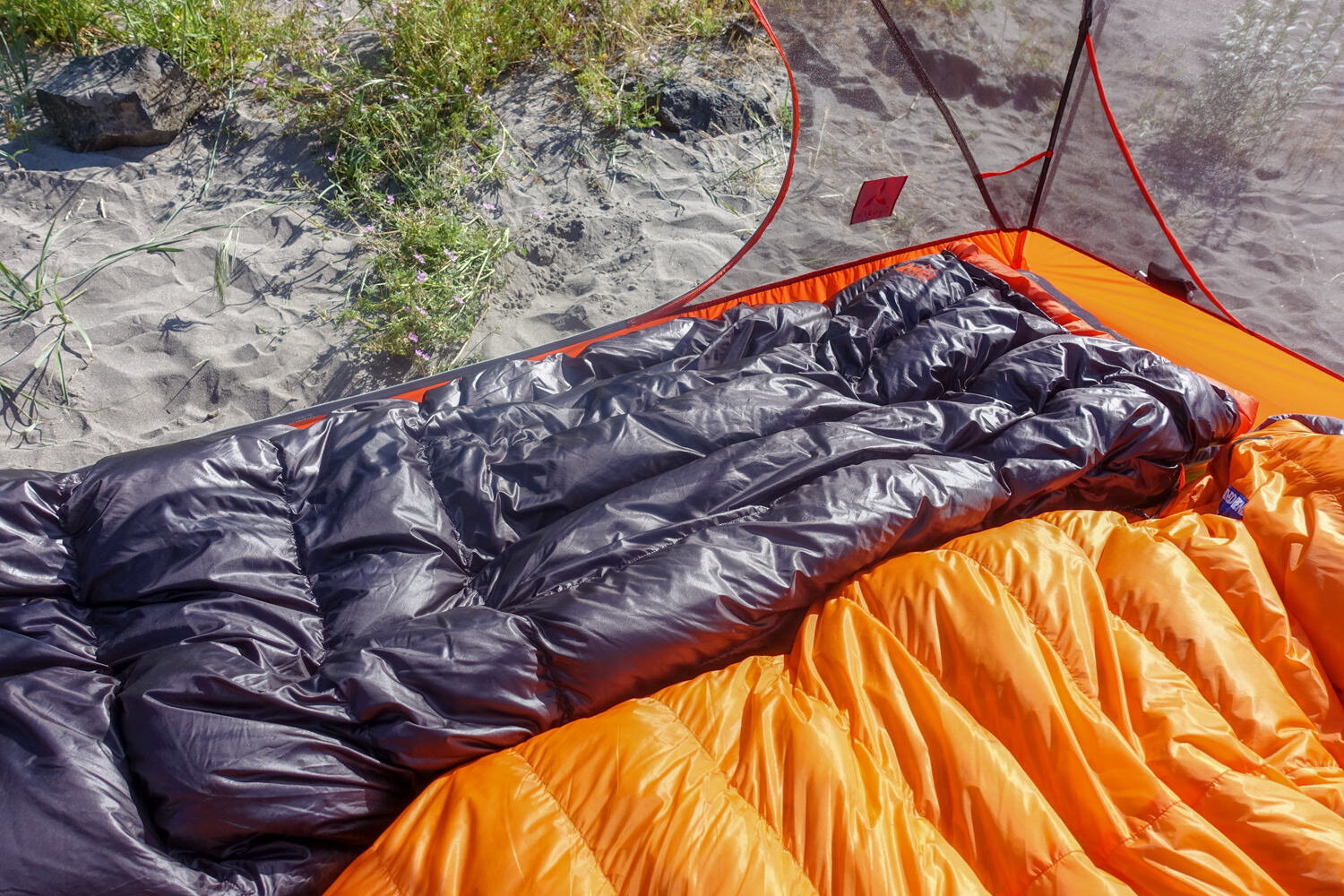 The REI Magma Trail Quilt 30 (left) is ultralight and super compact making it a great choice for summer backpacking.