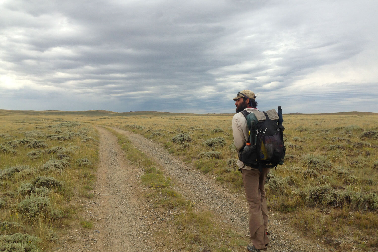 A dirt road leads through a vast basin of sagebrush in Wyoming