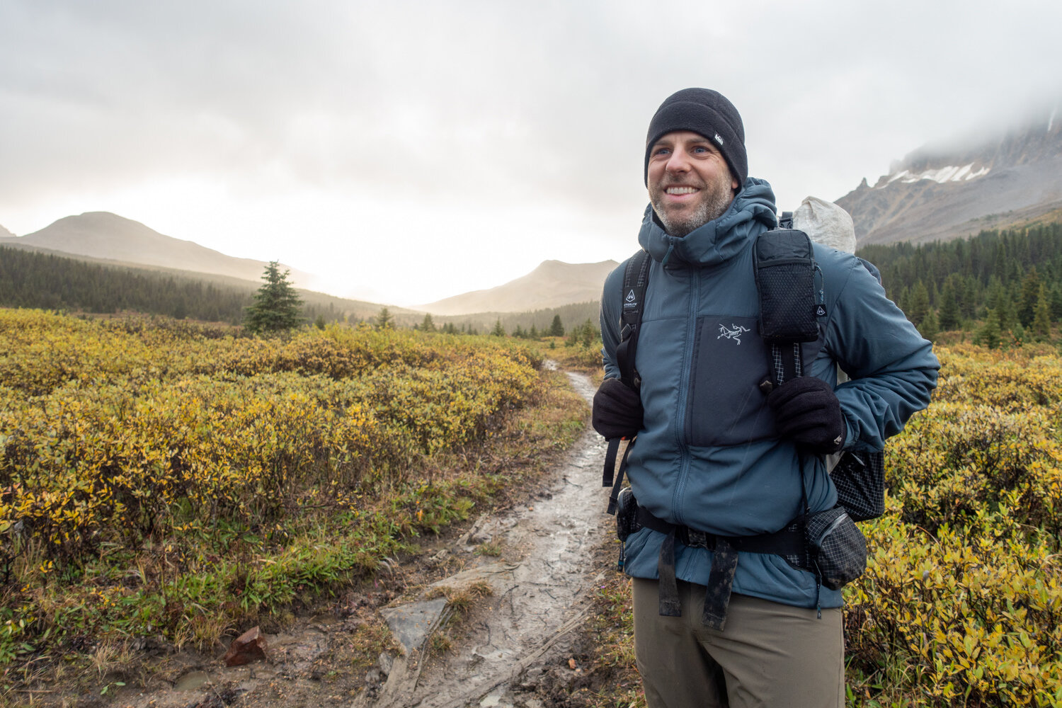 A backpacker wearing the Arc'teryx Proton LT Hoody.