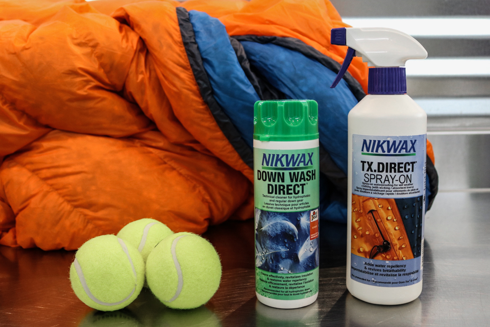 Nikwax Tech Wash and Direct Tx Spray with tennis balls and a down sleeping bag