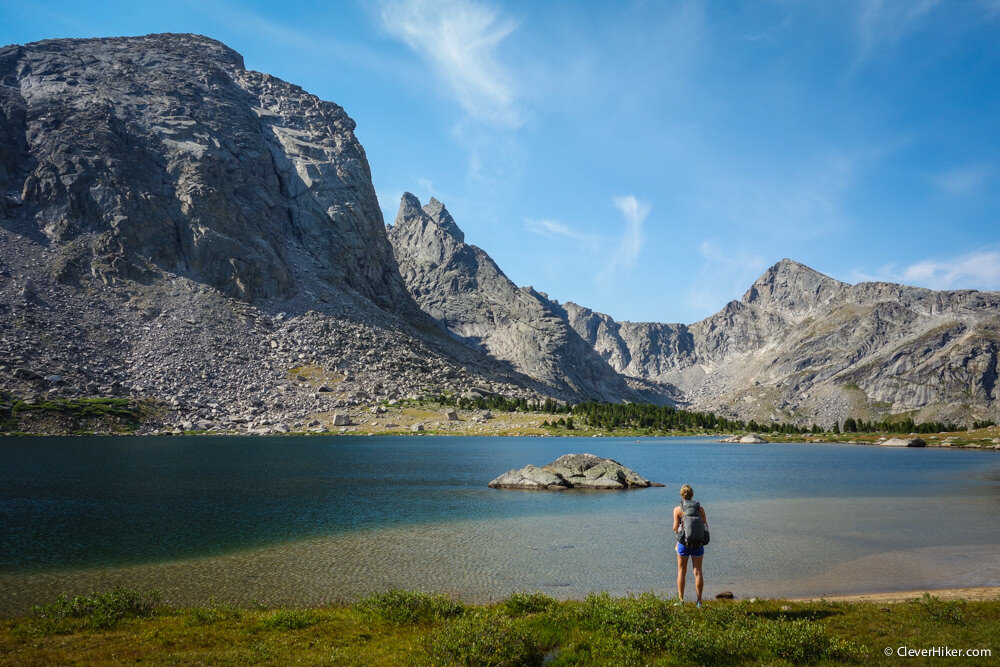 A hiker looking at a vista with a lake and some mountains