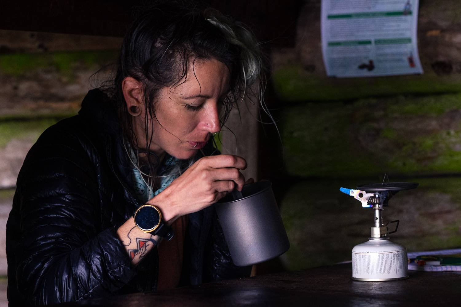A hiker sitting in a cabin eating out of a pot - the Snow Peak Litemax stove is set up in front of them
