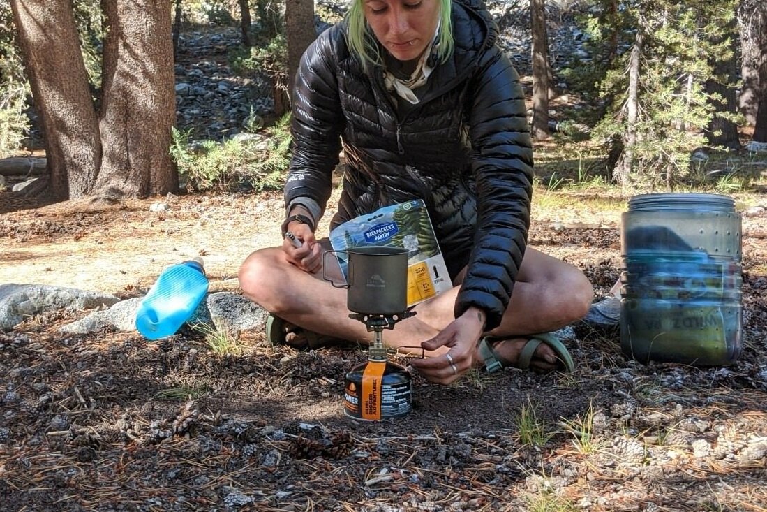 A hiker adjusting the flame on the Snow Peak Litemax