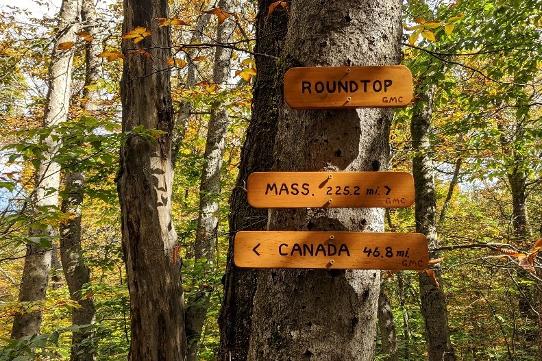 A Long Trail sign marking the distance to Massachusetts and the distance to Canada