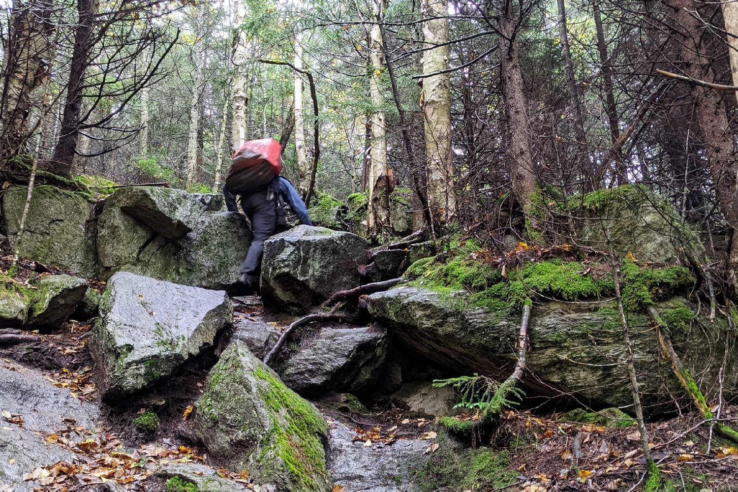 A Long Trail hiker climbing up some steep rocks