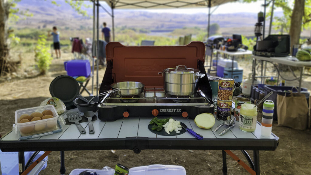 The Stanley Adventure Base Camp 4 Cookset with the Camp Chef Everest 2x stove on a table in a campsite