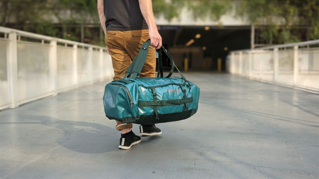 A man walking towards the airport with the Eagle Creek Cargo Hauler 60 duffel bag