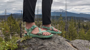 A hiker posing on a rock in the women's Chaco Z/1 Classic Sandals