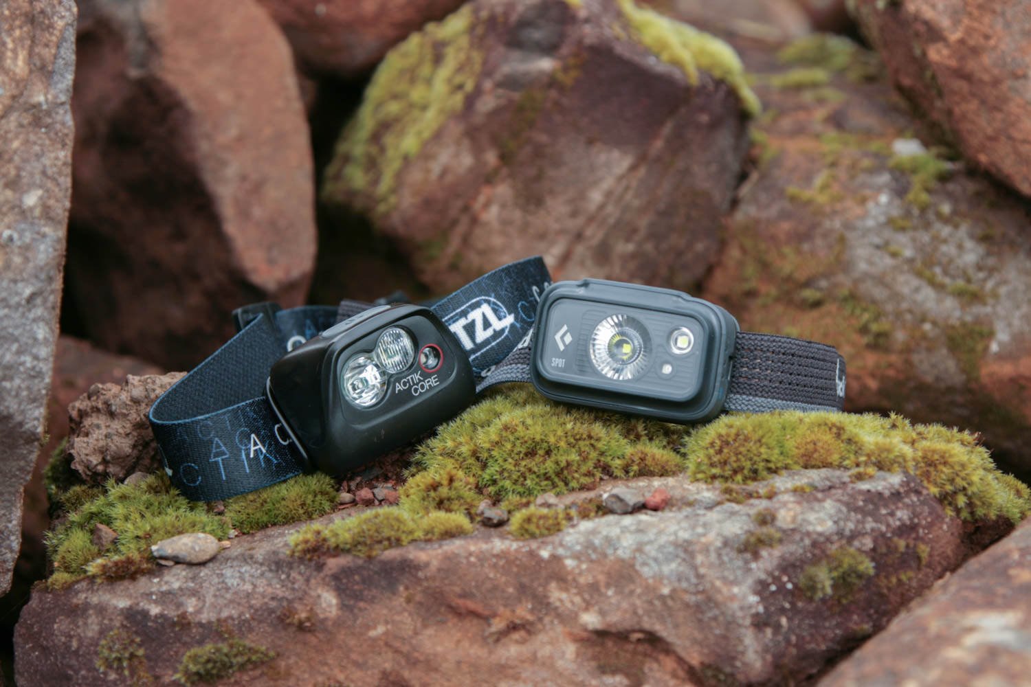 Petzl Actik Core headlamp and Spot 350 headlamp sitting next to each other on a rock