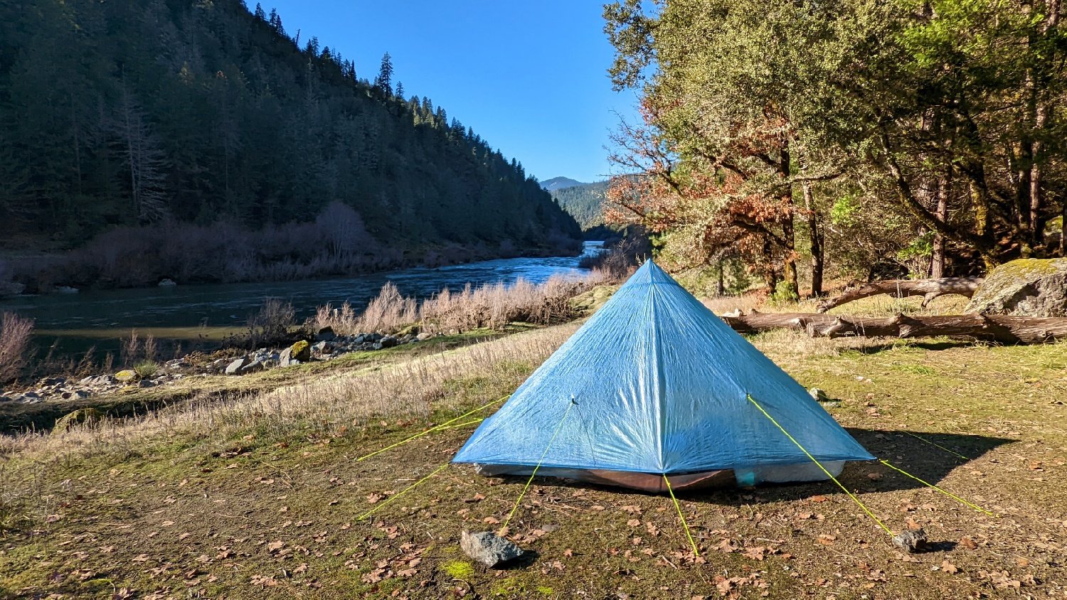 The Zpacks Plex Solo tent sitting in front of a river view