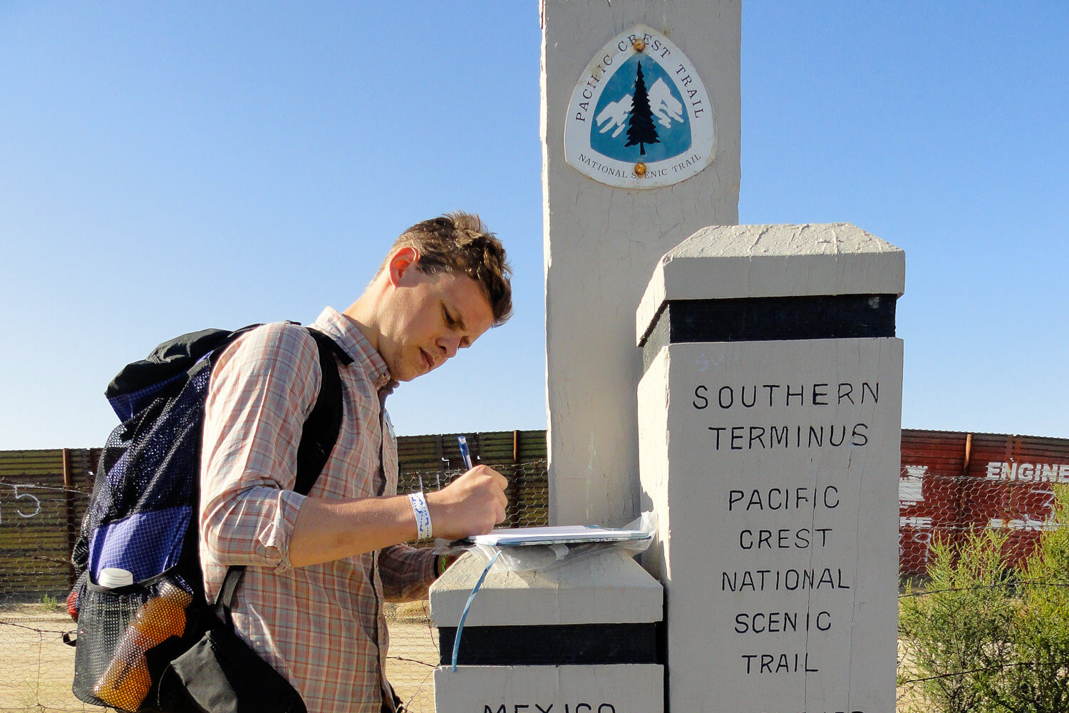 A Thru-Hiker writes in the log book at the Southern Terminus Near Campo, CALifornia