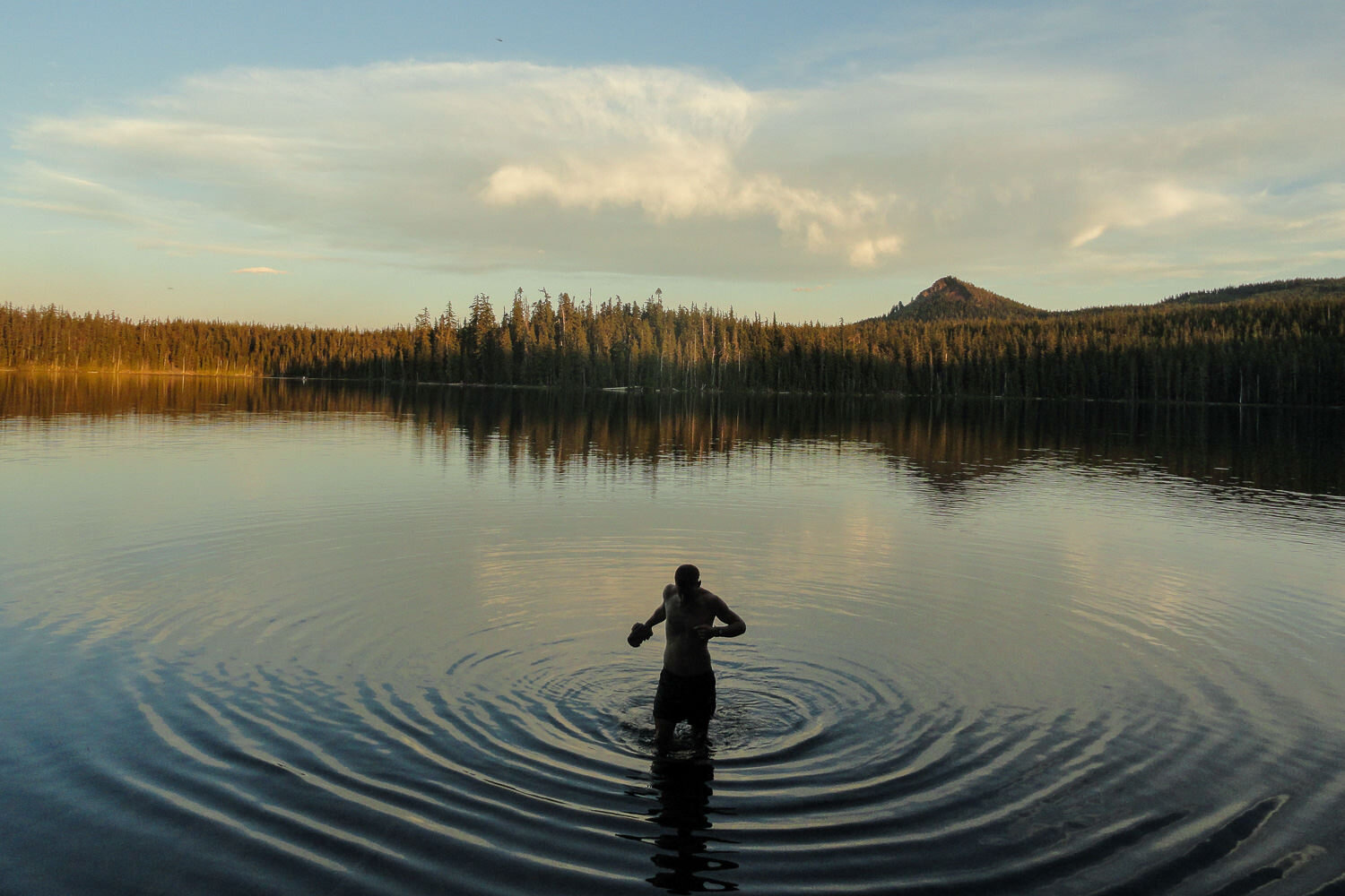 A hiker takes a well-deserved evening dip in one of oregon’s Cascade lakes