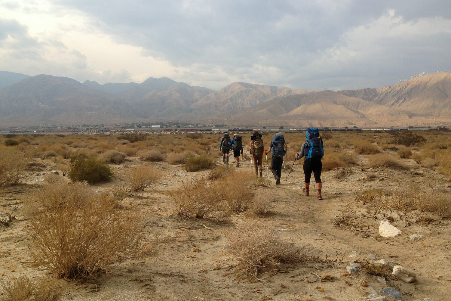 A parade of hikers make their way towards the highway 10 underpass near san Gorgonio Pass