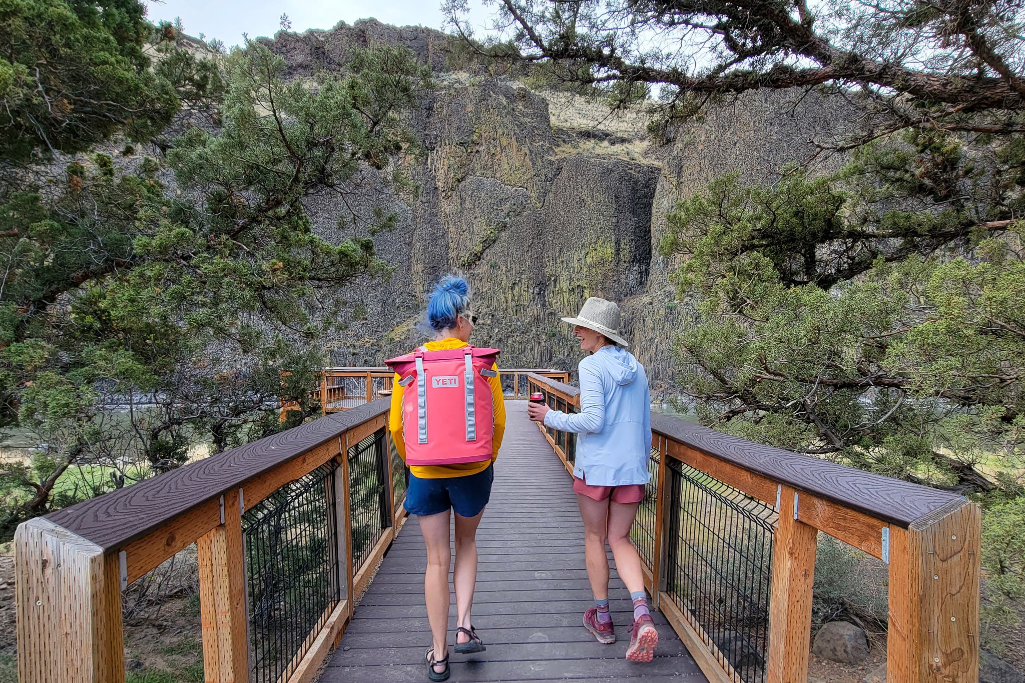 Two women walking out to a viewpoint overlooking the Crooked River with the Yeti Hopper M20 Backpack Cooler