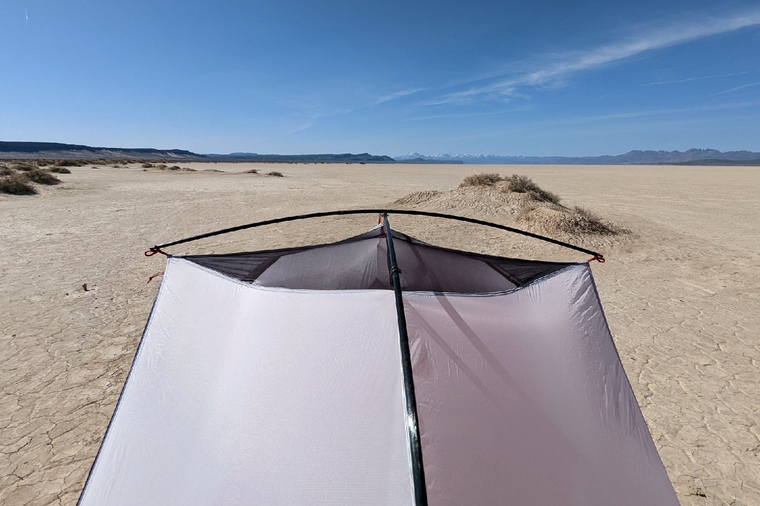 Close up of the top of a tent featuring it's hubbed pole setup with a wide open desert in the background.