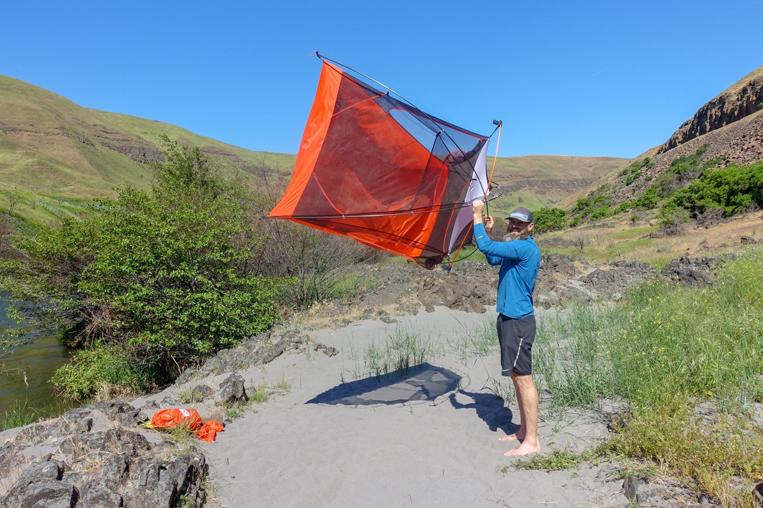 Shaking sand out of the Slingfin Portal tent before packing it up