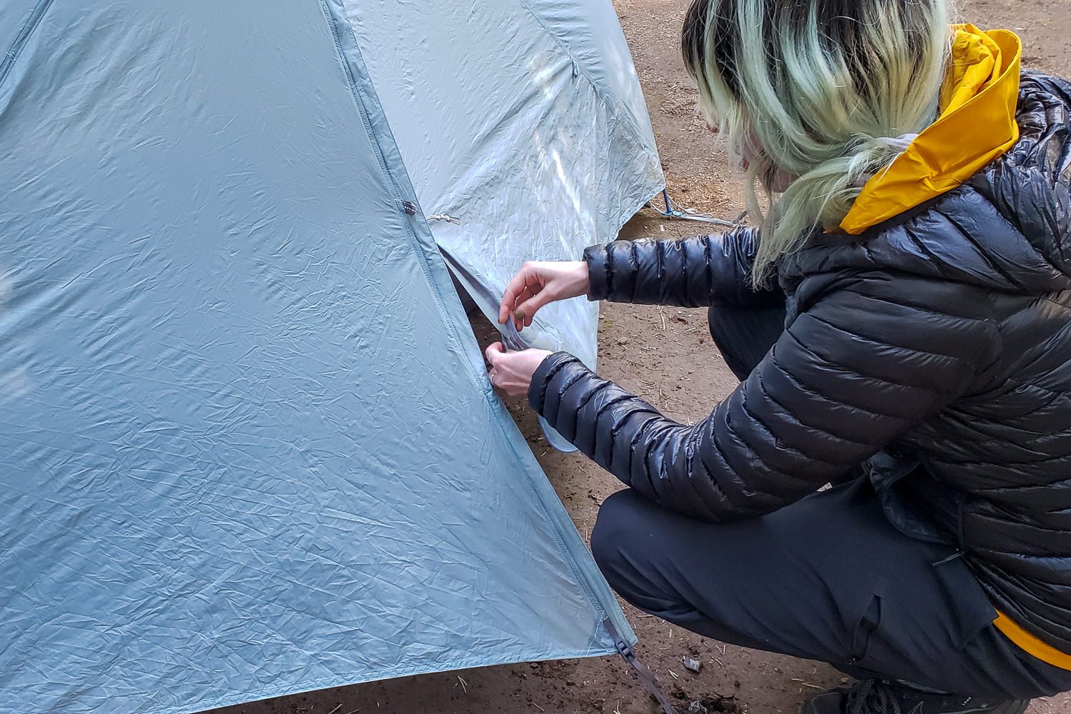 A hiker inspecting the seams of the Seas to Summit Telos 2 tent to see if they need to be resealed