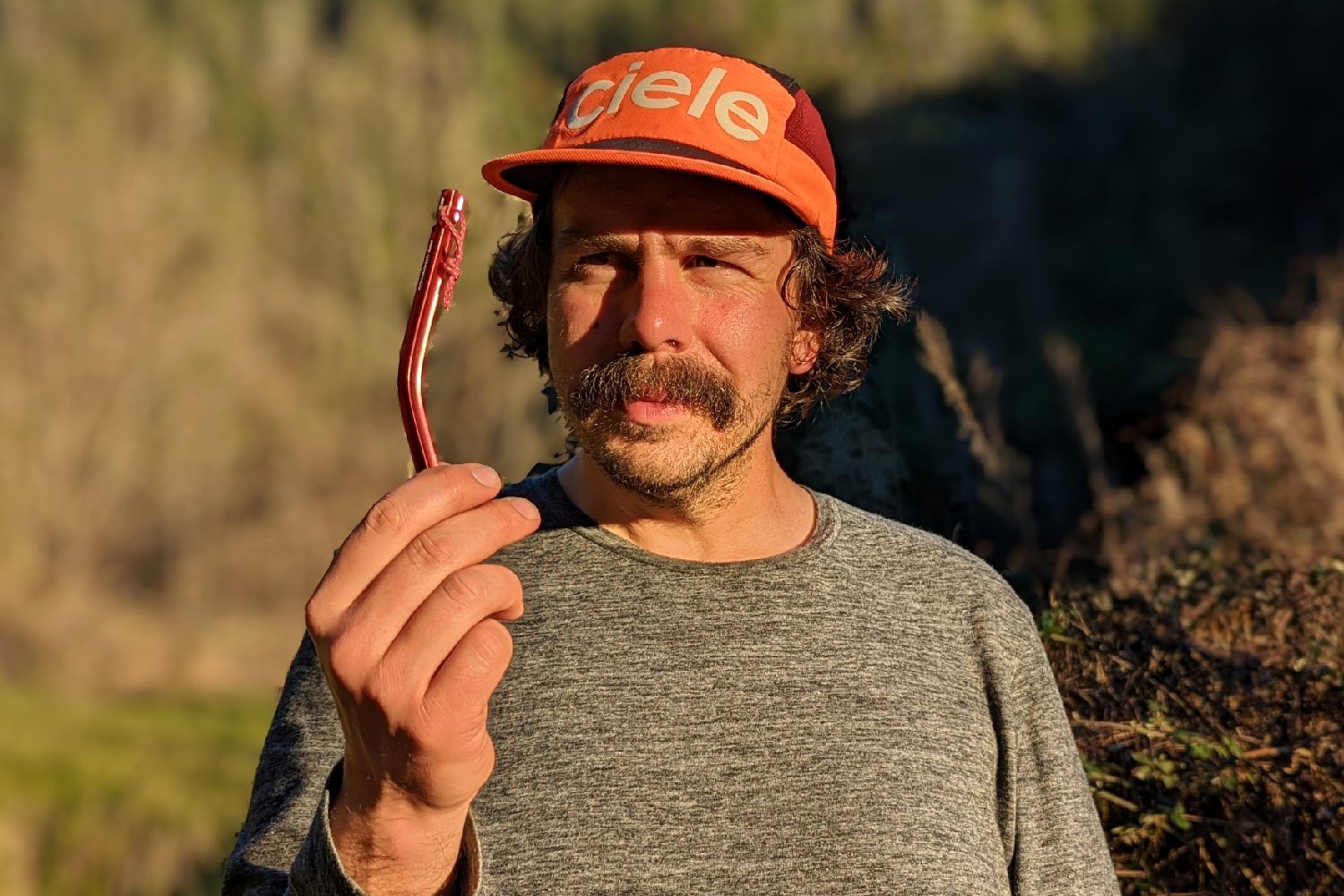 A backpacker holding a bent tent stake