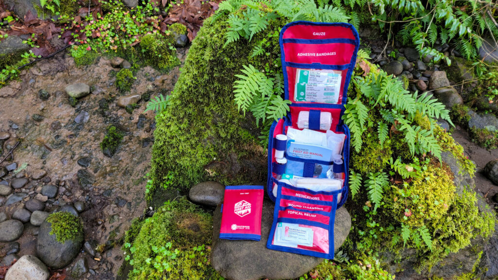 The HART Extended First Aid Kit on a rock with moss and ferns