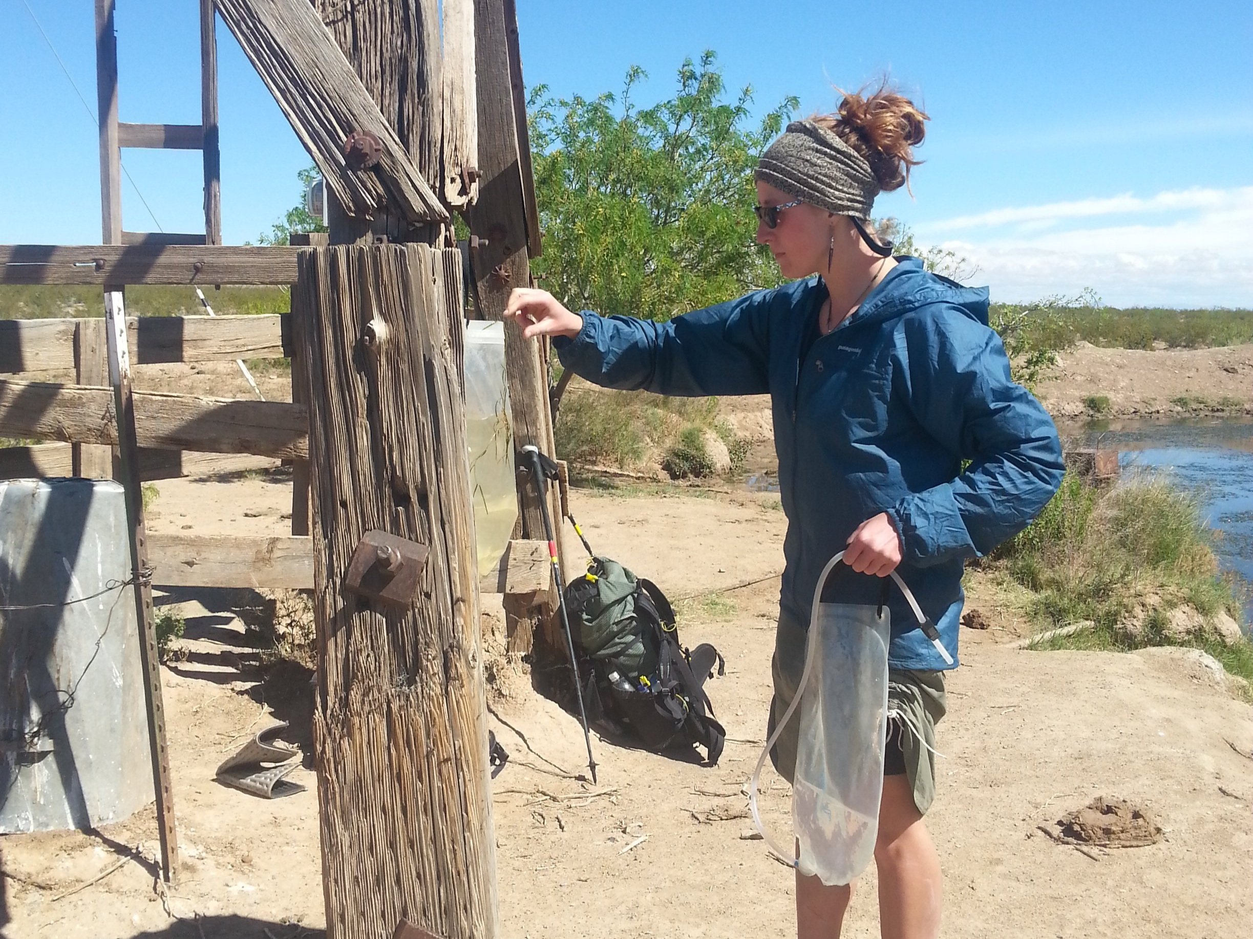 A backpacker using the Platypus GravityWorks to filter water from a cattle tank on the Continental Divide Trail