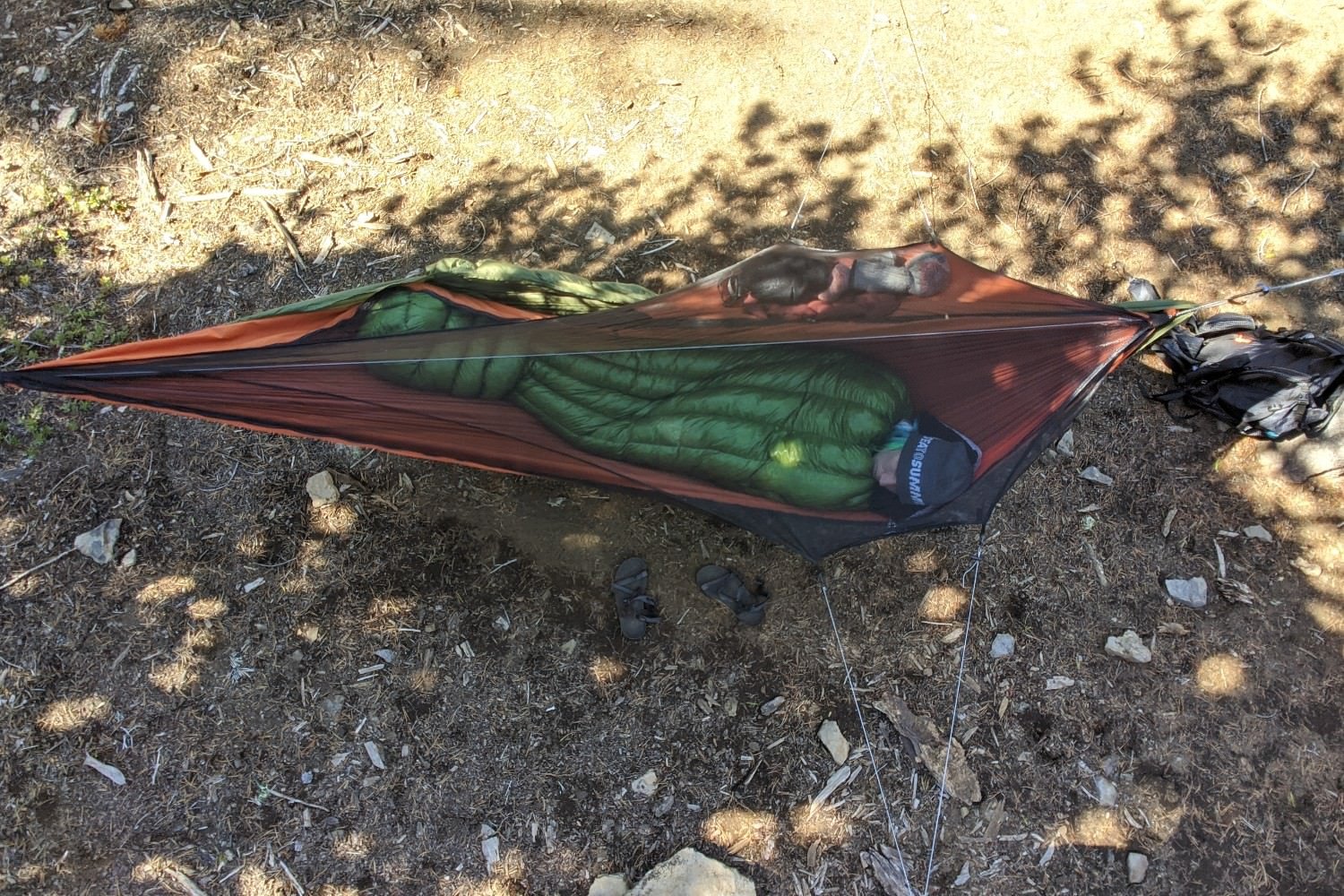 A hiker sleeping in a hammock with the ZPacks Classic Sleeping Bag