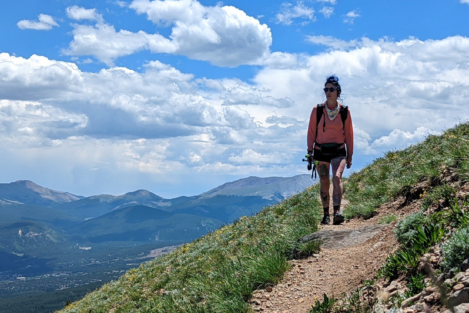 A hiker on the Colorado Trail with mountains in the background