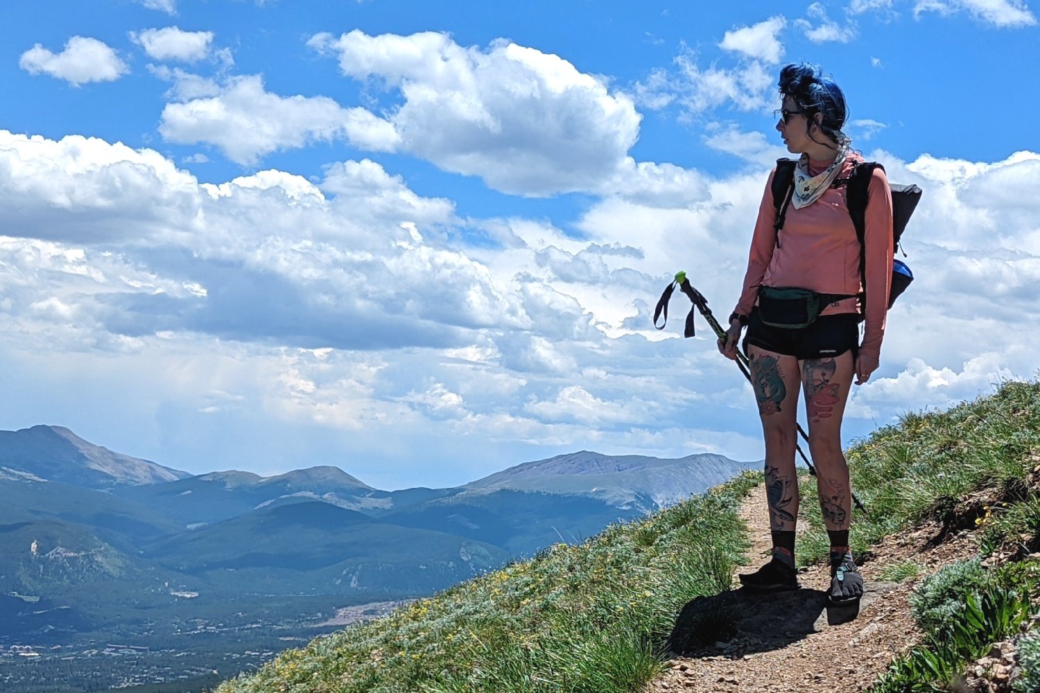 a hiker standing on a ridge looking at a mountain view on the Colorado Trail