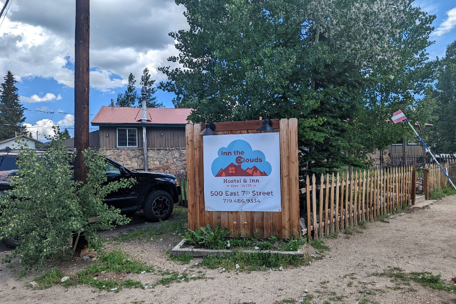 A sign for the Inn the Clouds Hostel in Leadville Colorado