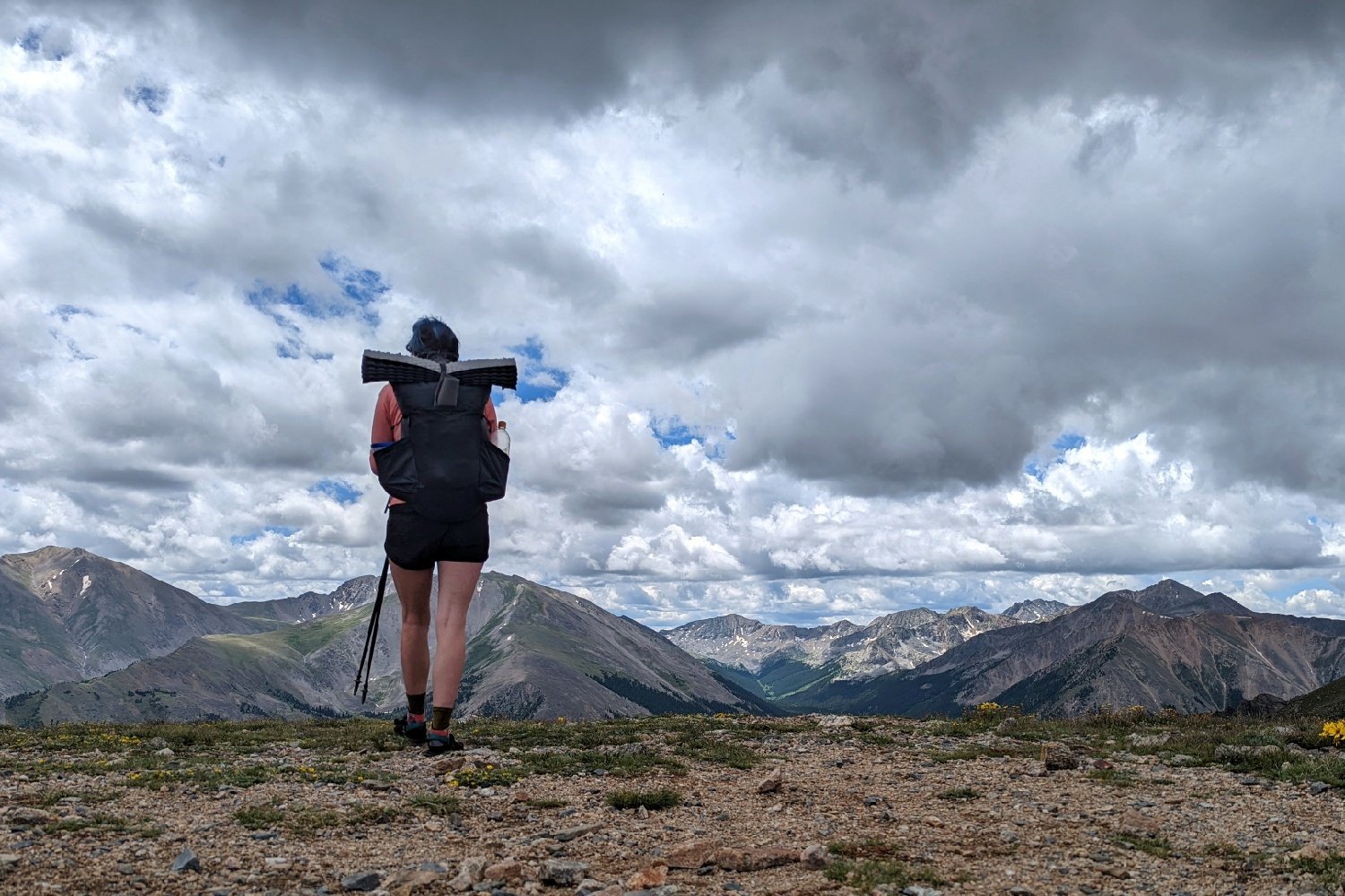 A hiker standing at the top of a mountain pass on the Colorado Trail