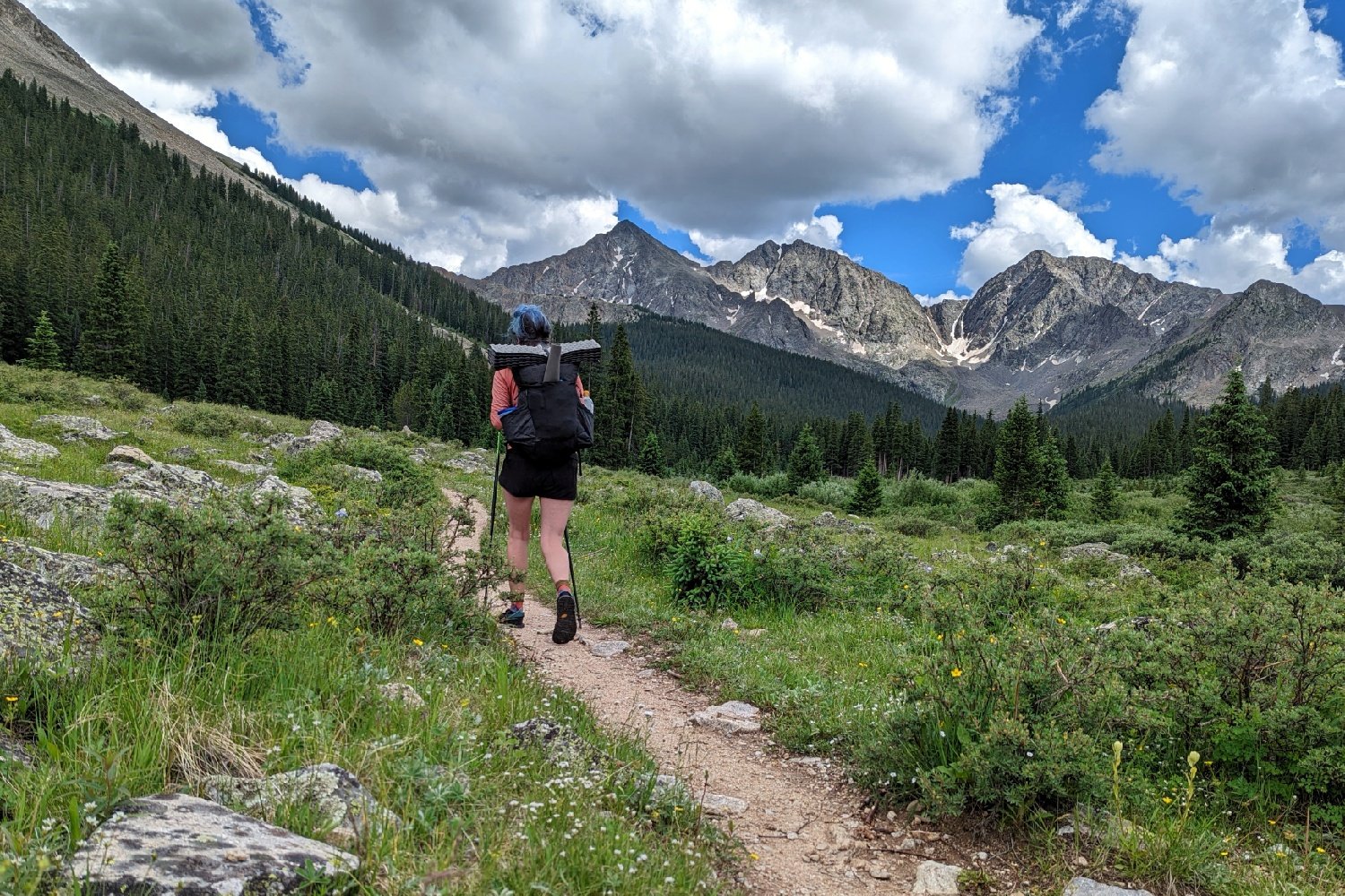 A hiker walking towards some high peaks on the Colorado Trail