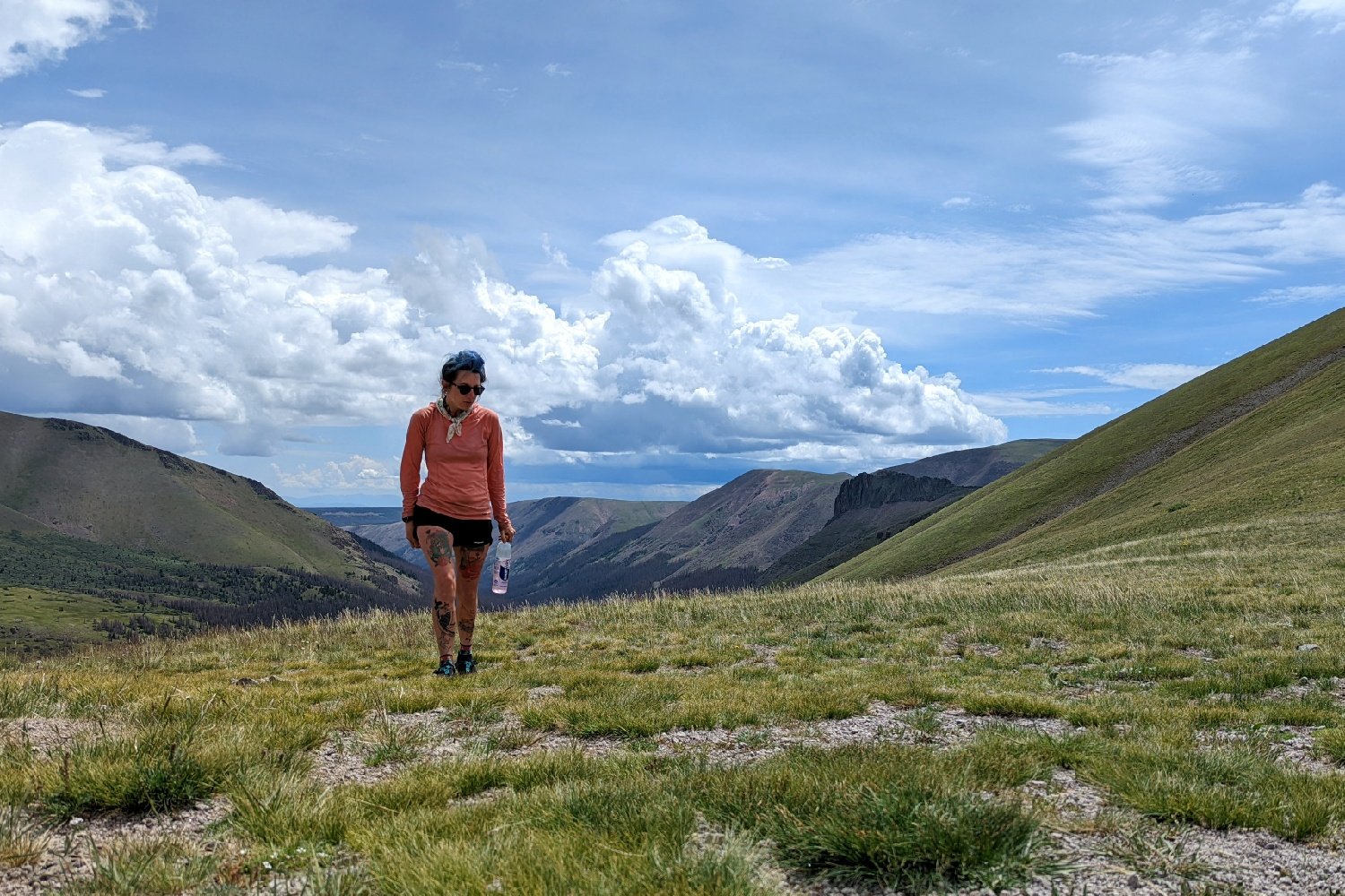 A hiker at the top of a mountain pass on the Colorado Trail