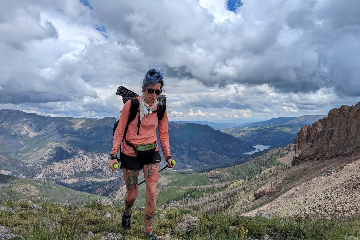 A hiker at the top of a mountain pass on the Colorado Trail