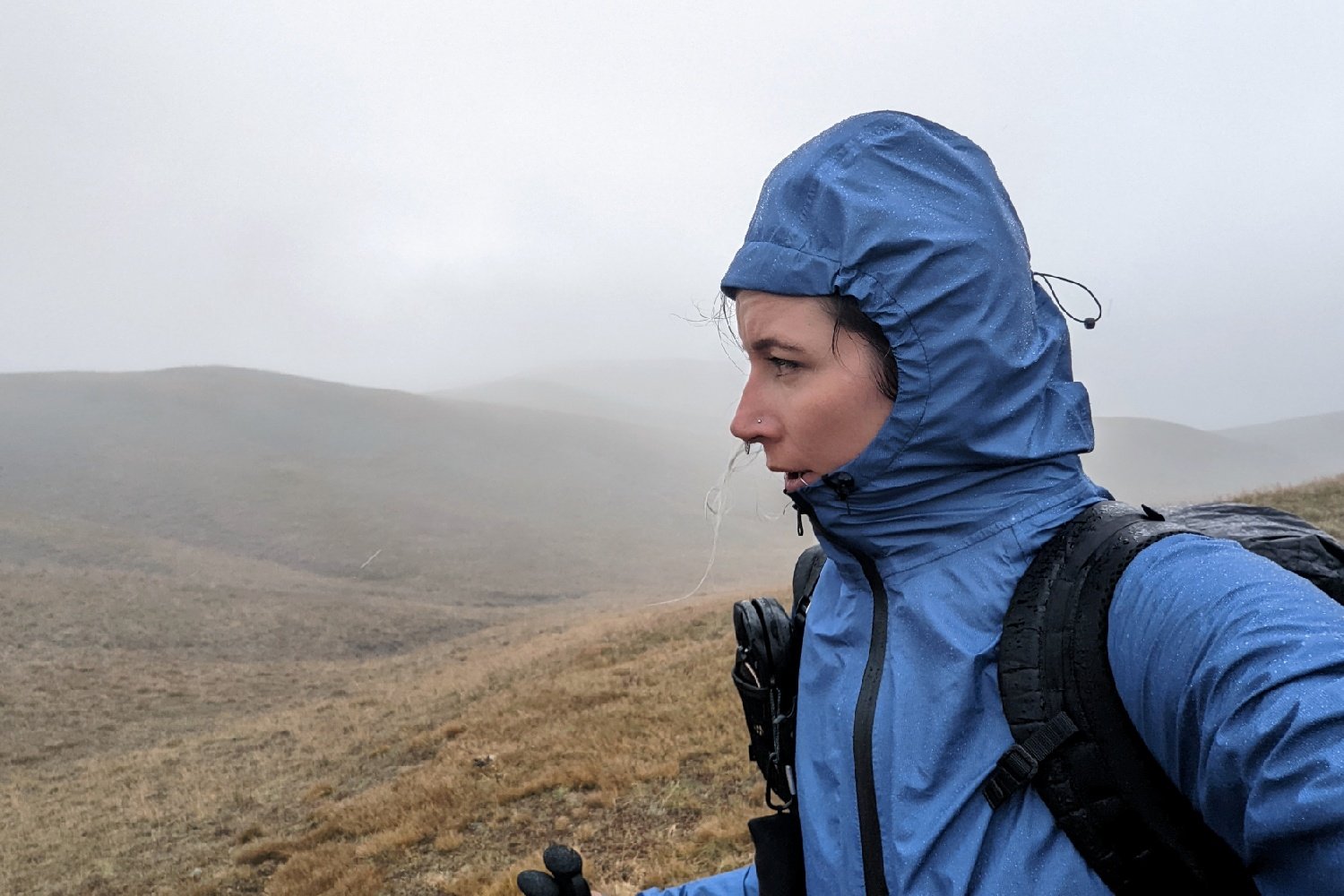 A hiker wearing a rain jacket with a hood in rainy weather on the Colorado Trail