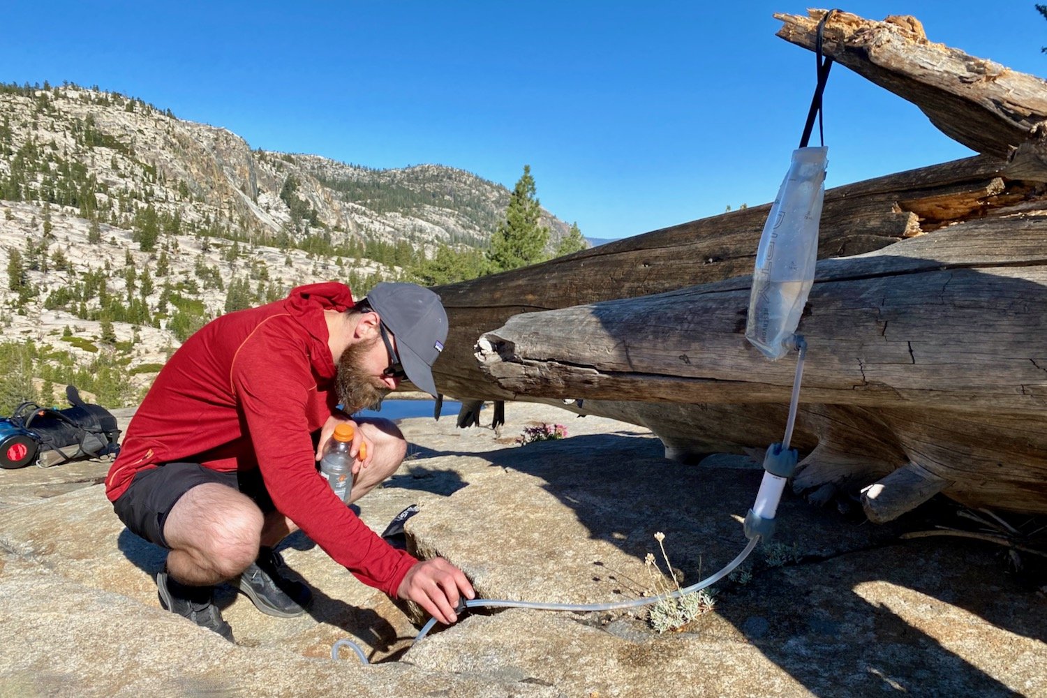 A backpacker using the Platypus GravityWorks to filter water