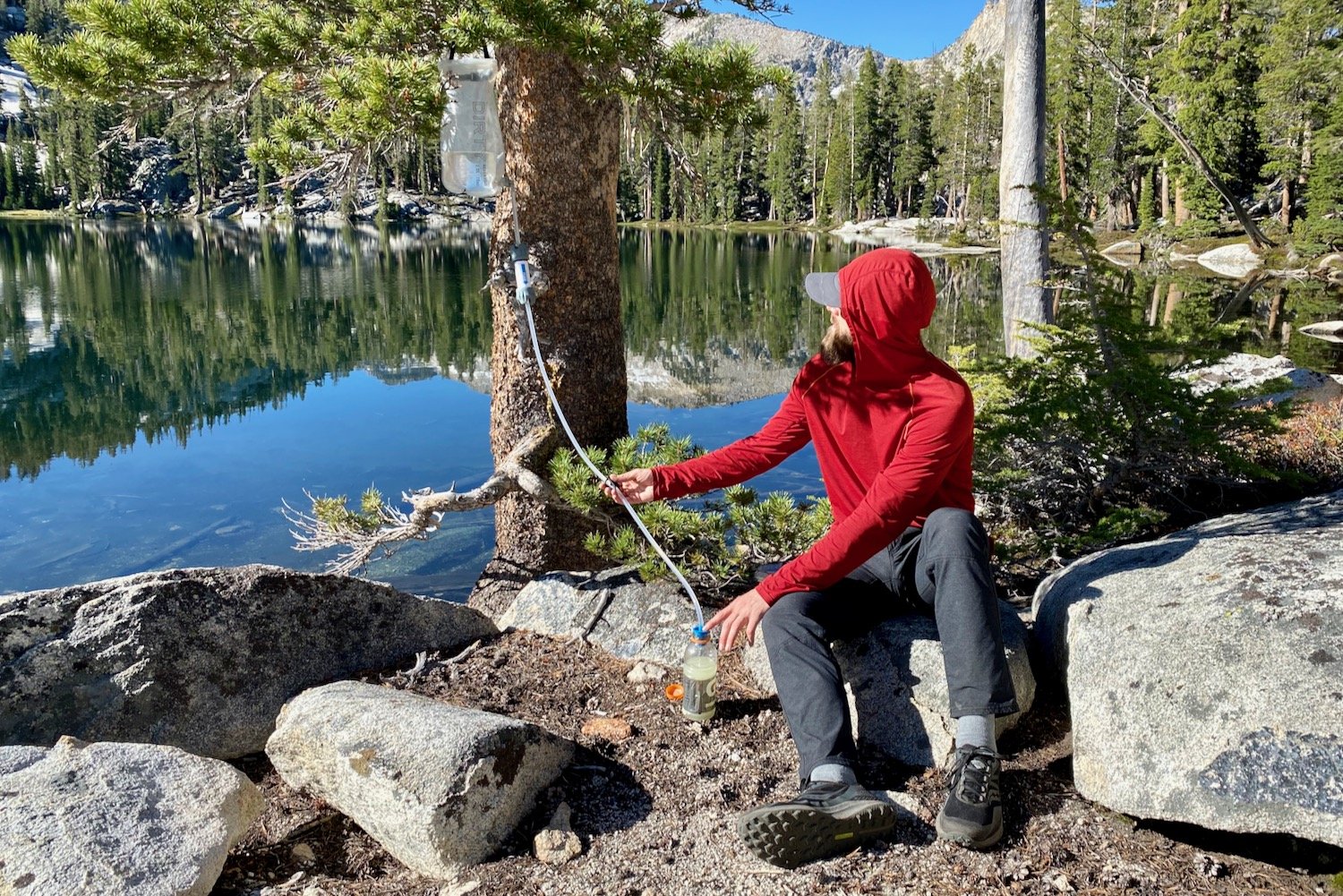 A backpacker using the Platypus GravityWorks Filter