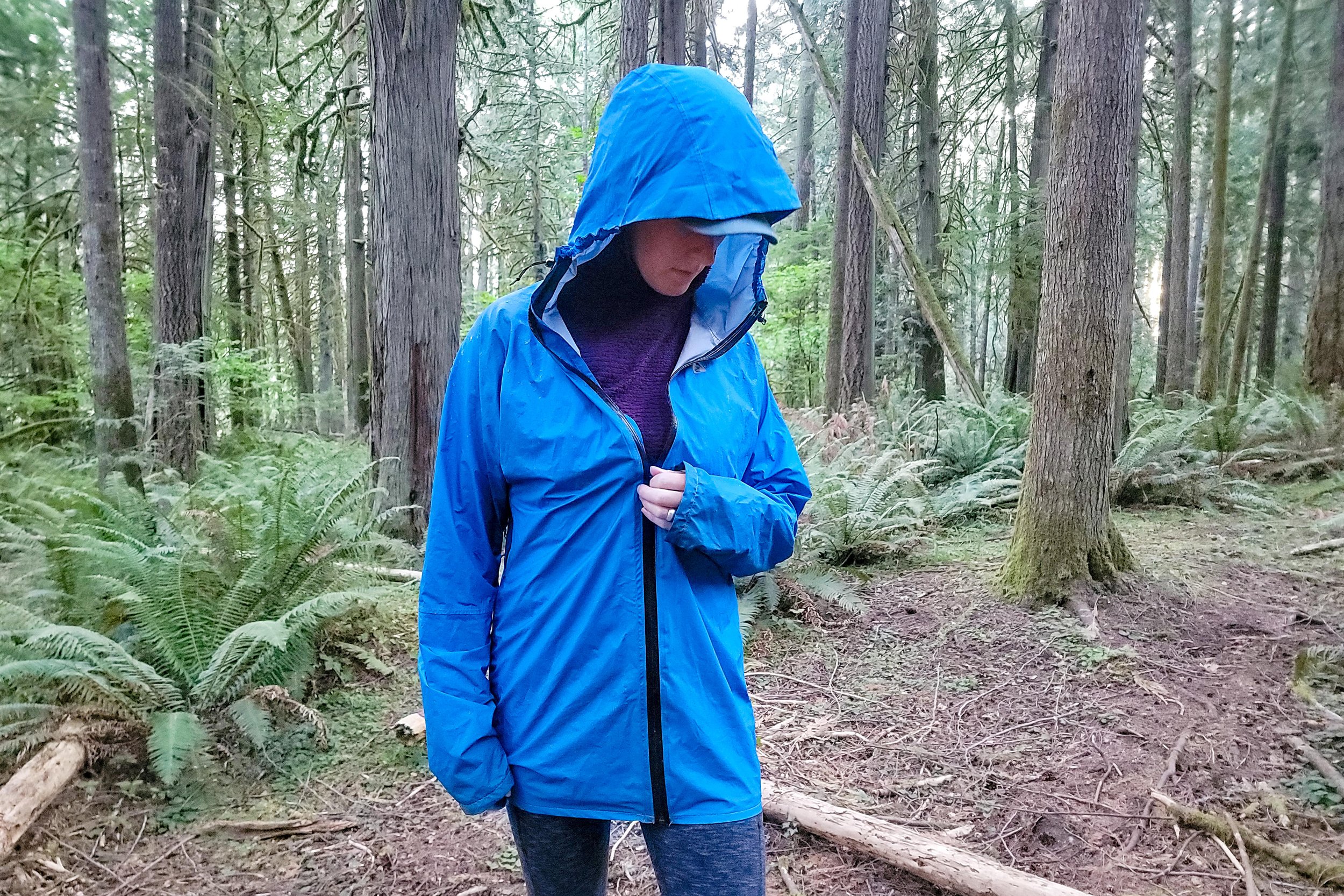 A hiker wearing the Zpacks Vertice Jacket in a forest