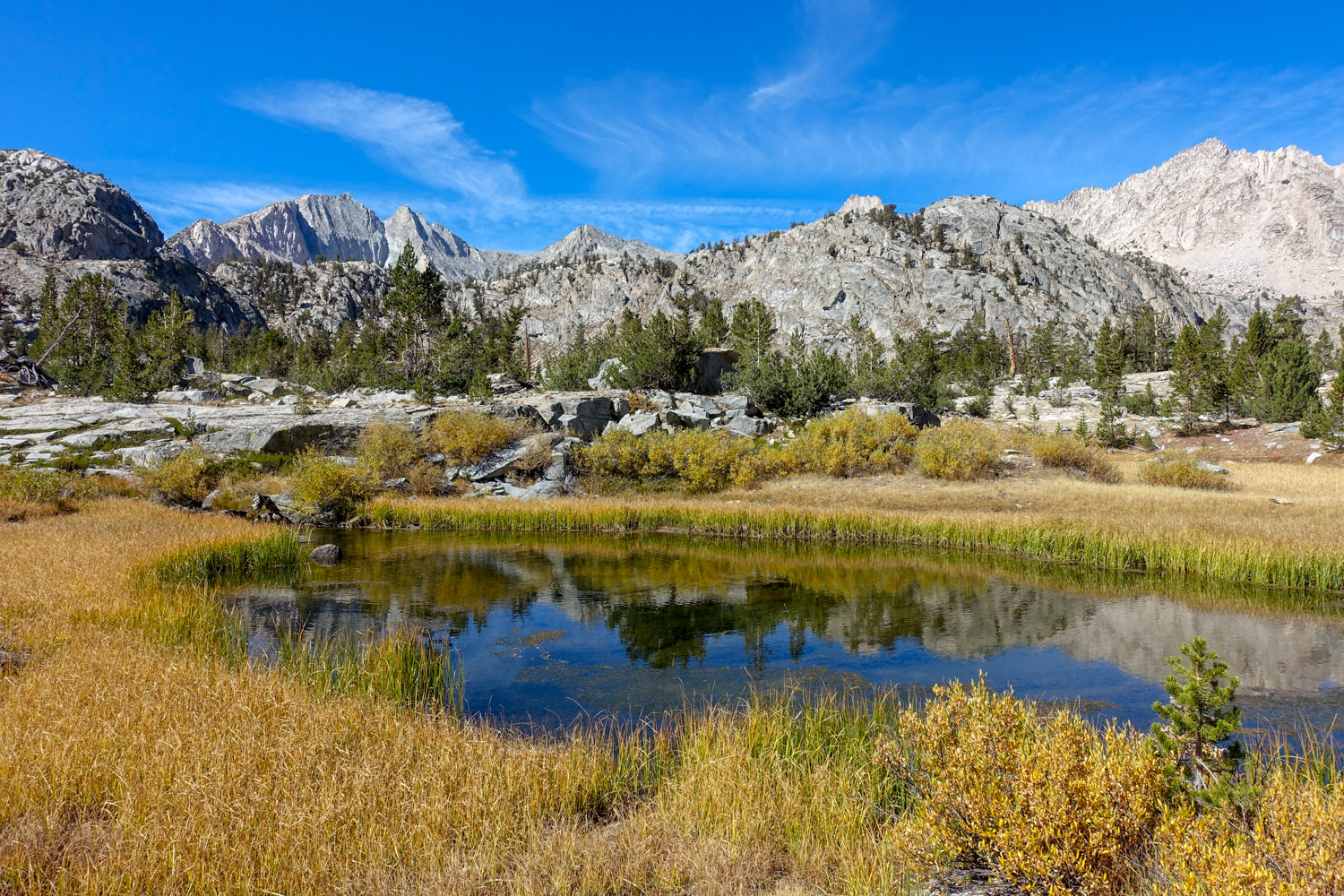 small lake on the JMT with granite mountains in the background.