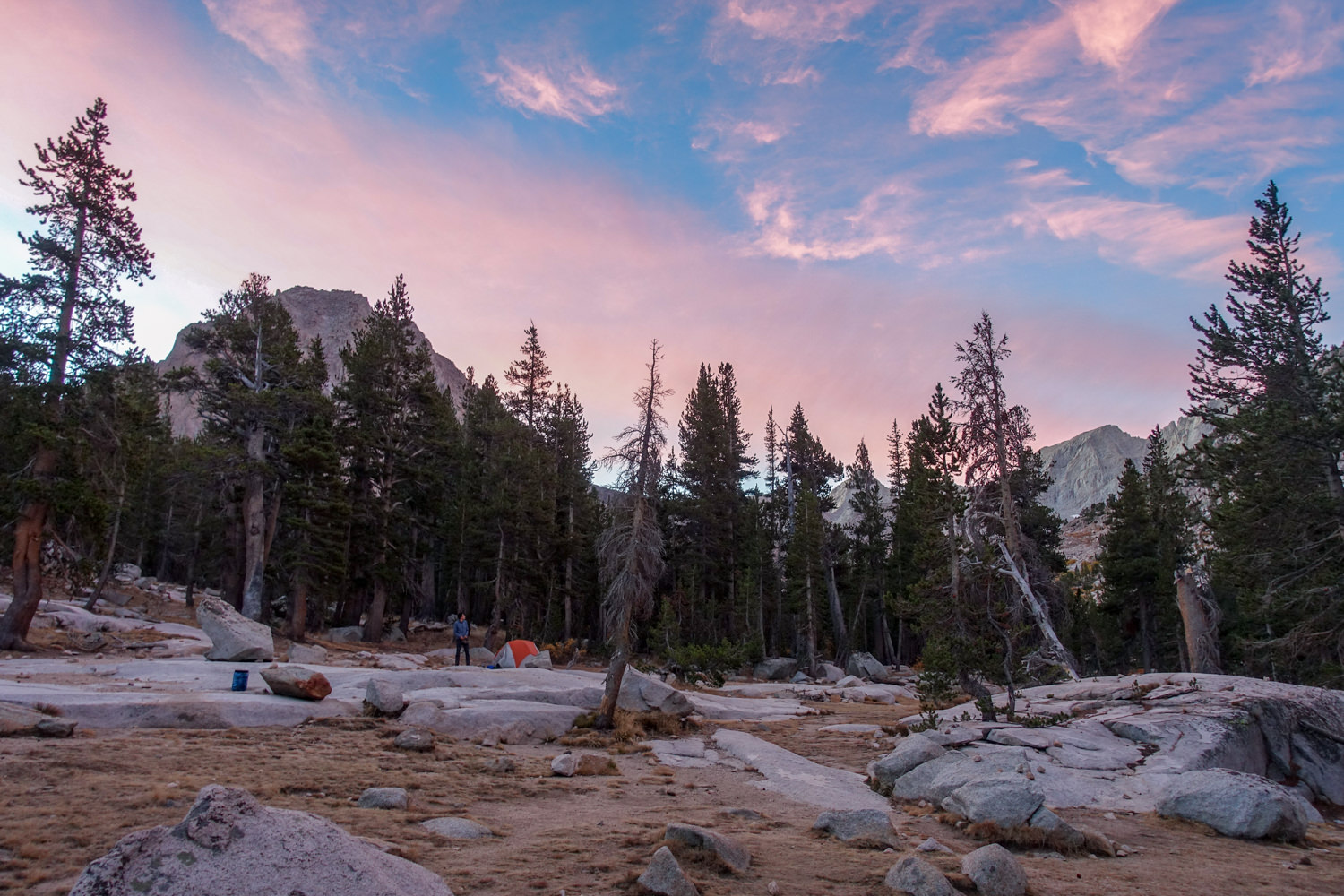 sunset over campsite with tent set up and bear can stashed at a safe distance away.