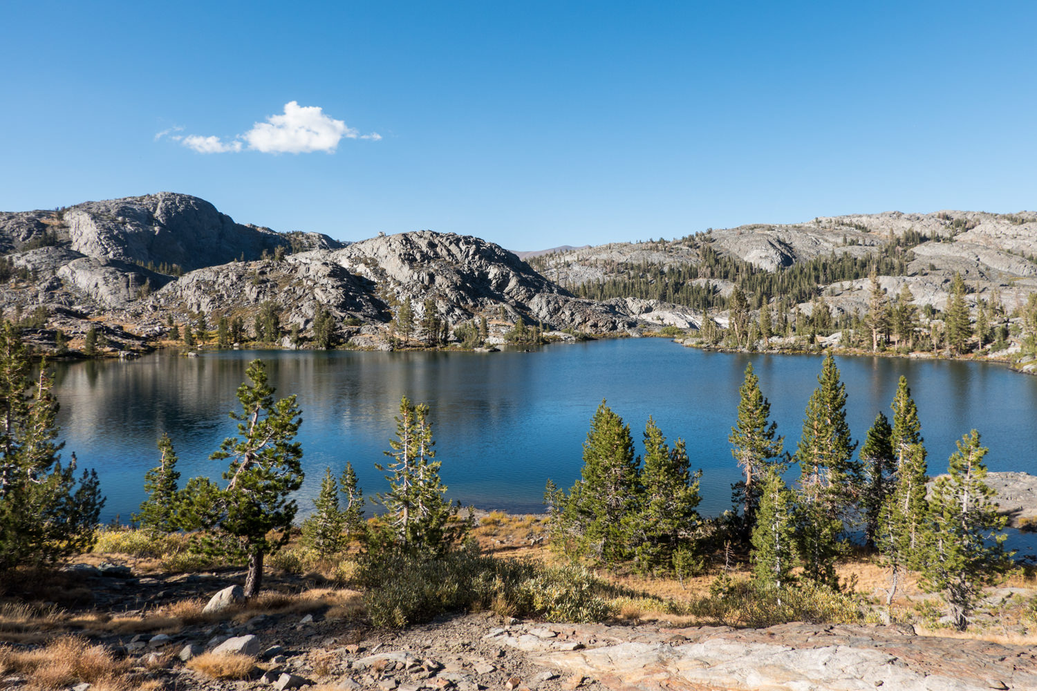 alpine lake with one cloud in a blue sky on the John Muir trail