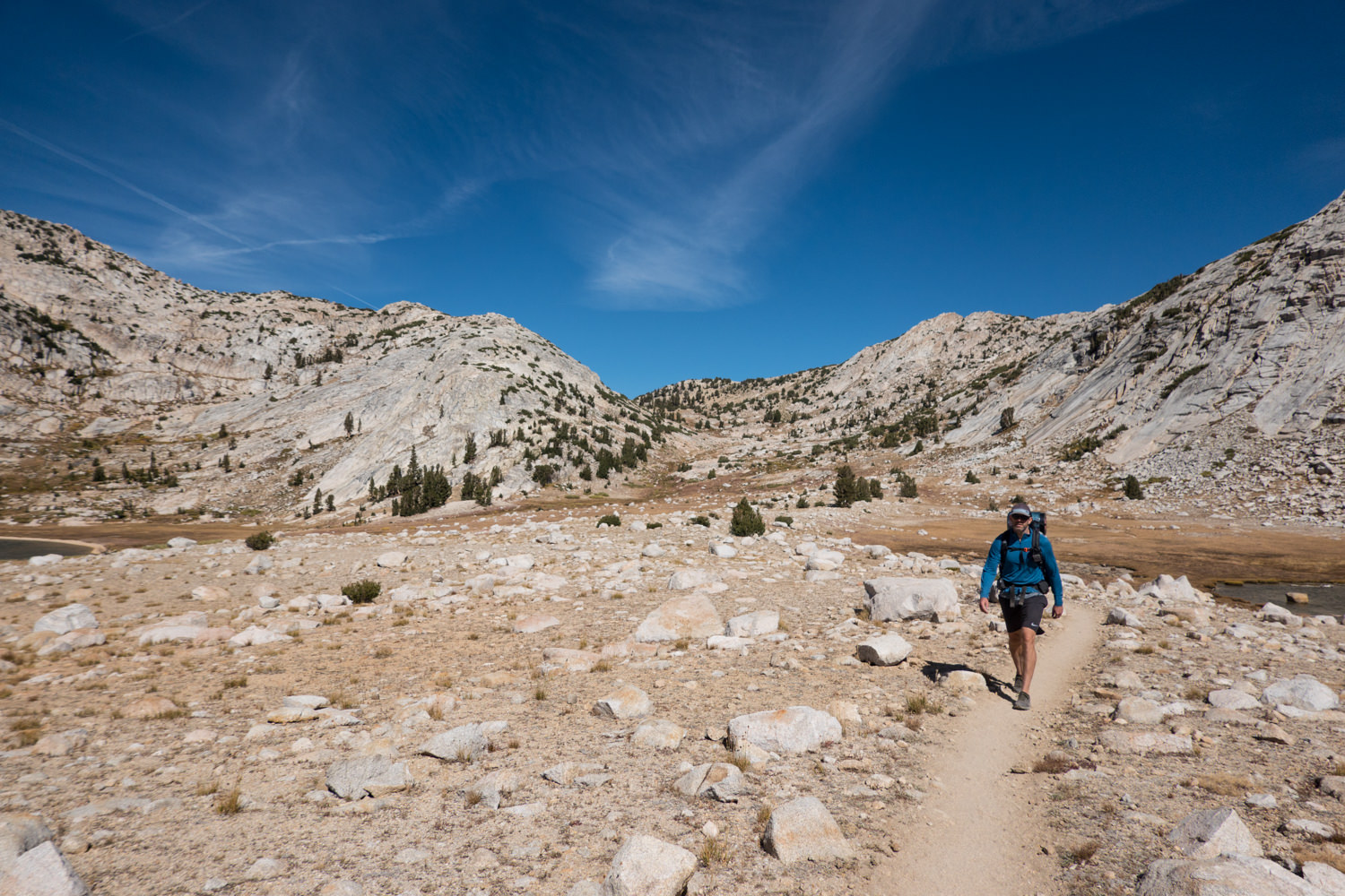 Backpacker on the JMT in a high sierra basin.