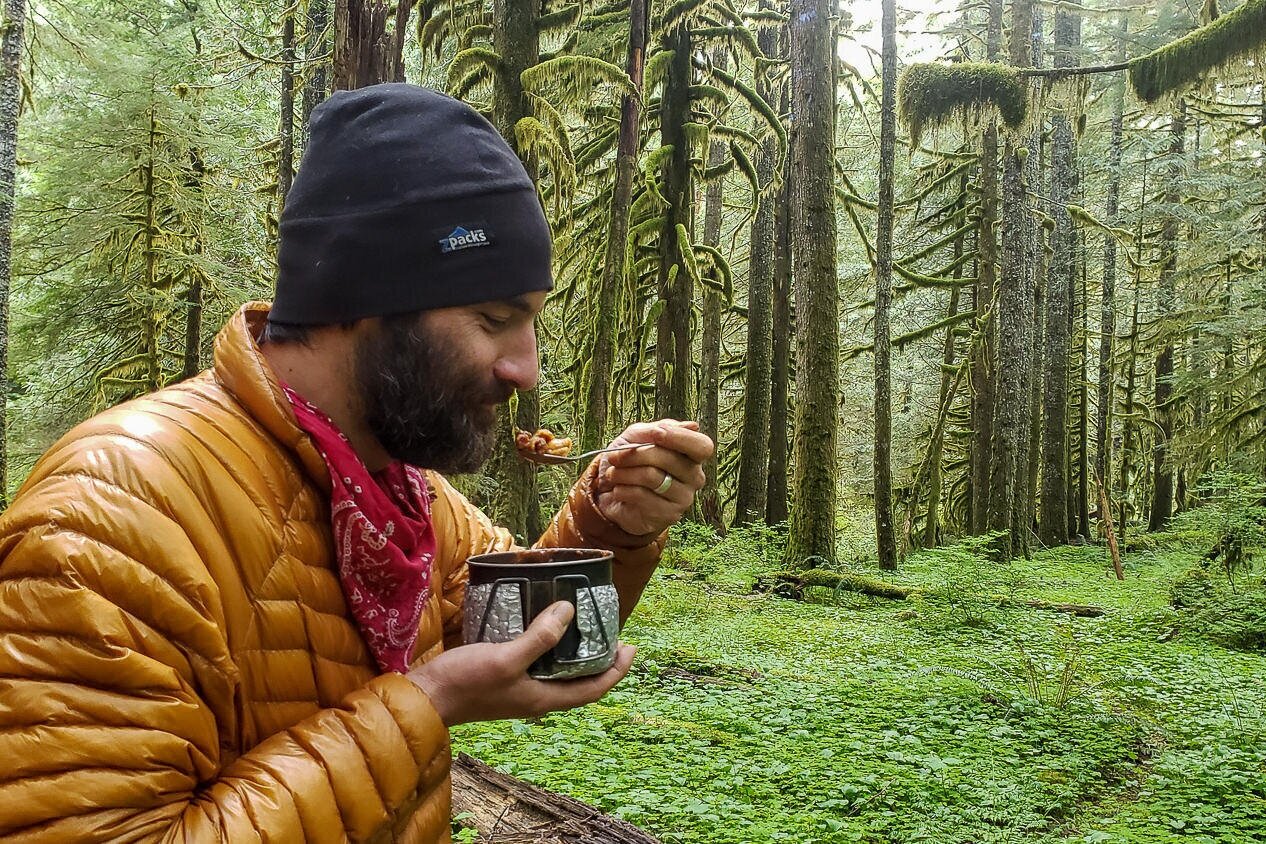 Closeup of a hiker eating out of backpacking cook pot.