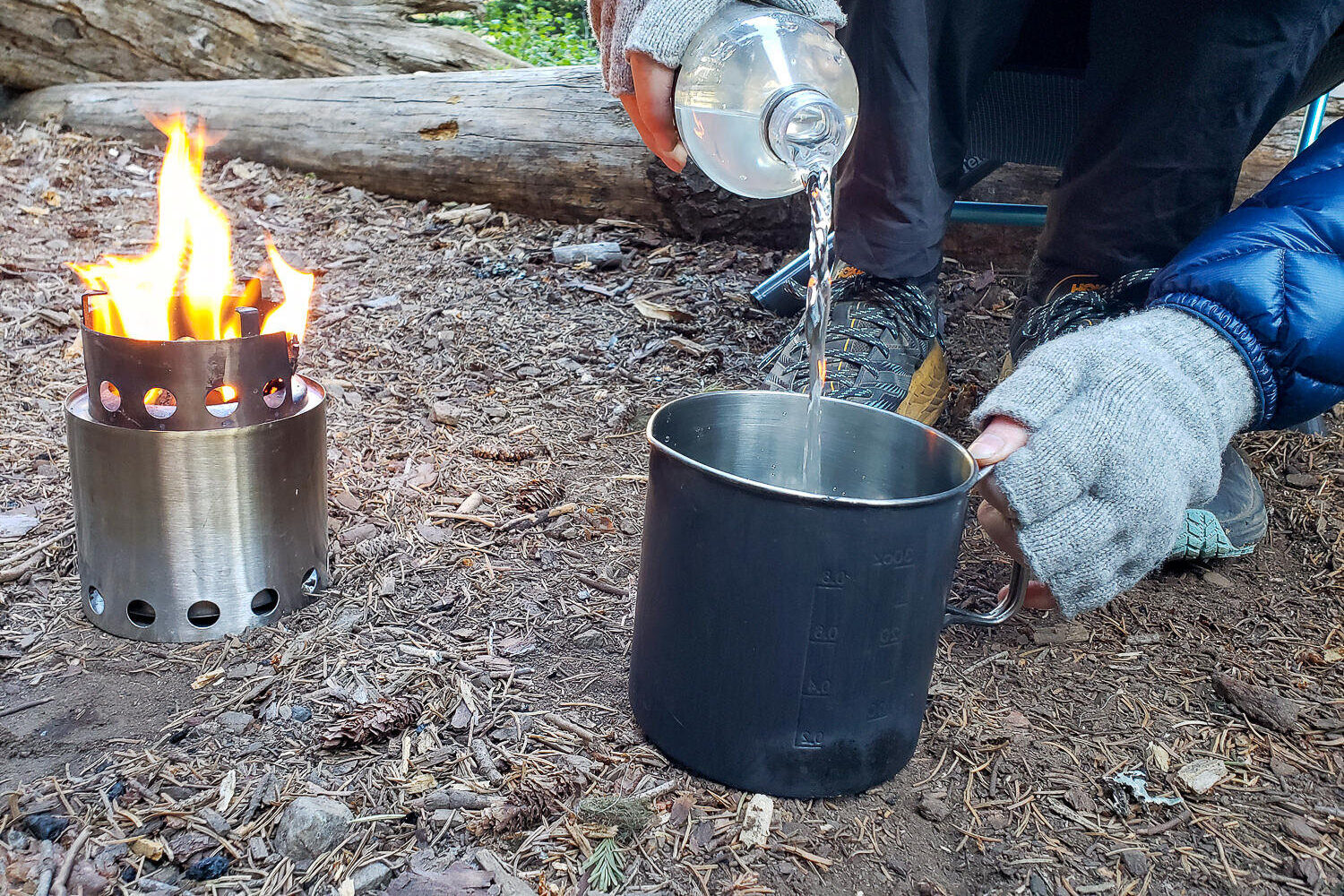 person pouring water into a pot in the backcountry