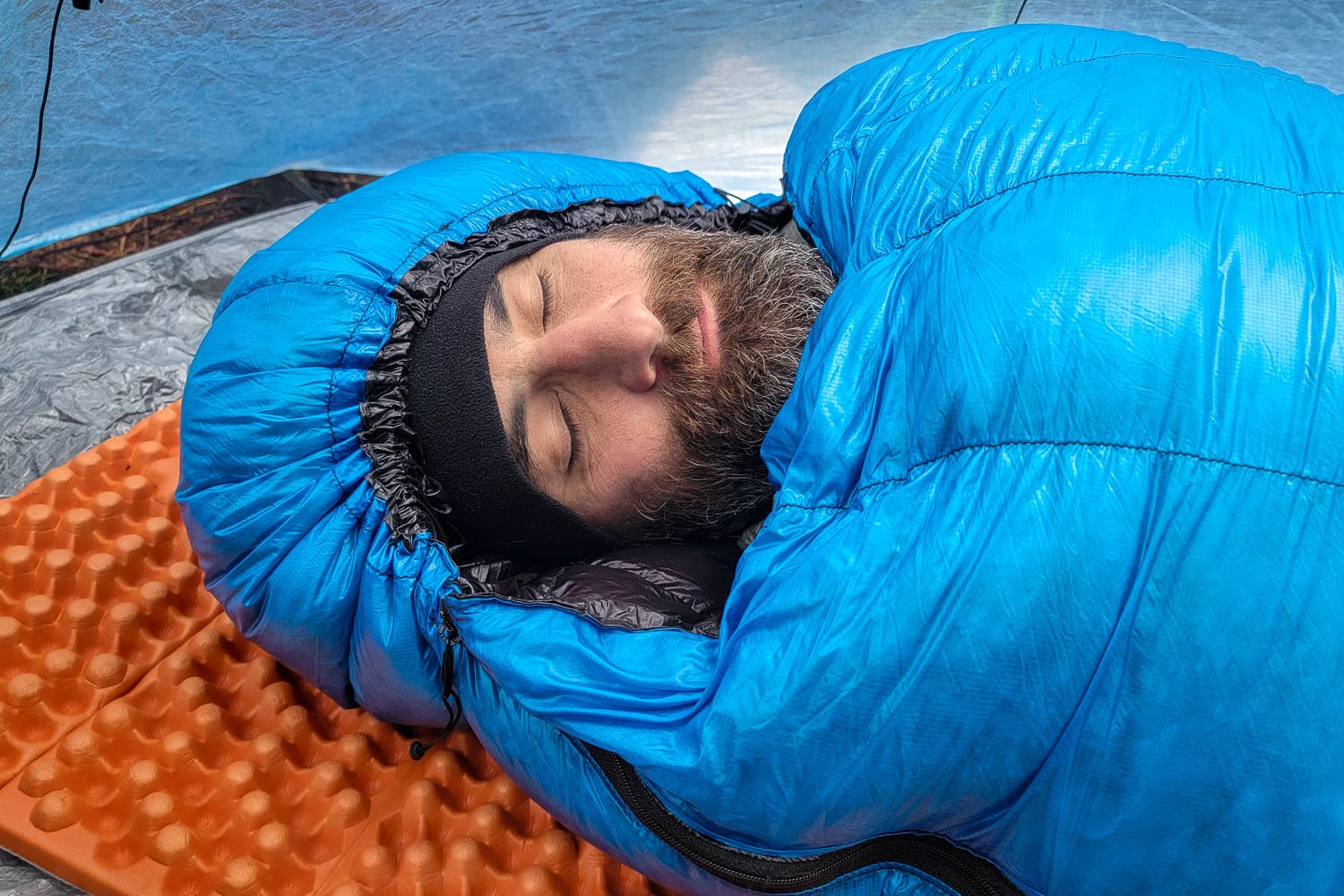 Closeup of the Zpacks Mummy Bag hood cinched around a sleeping man's face